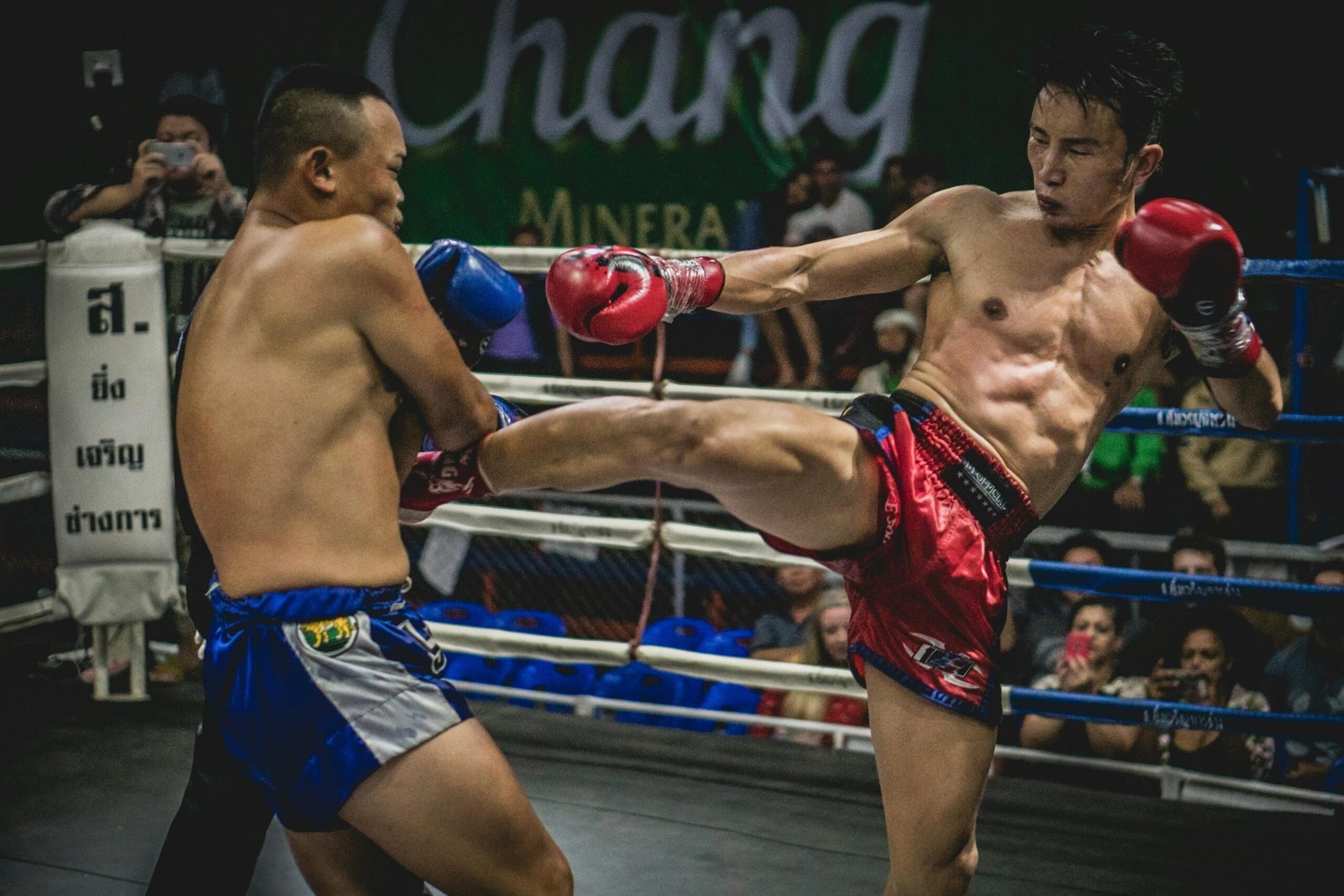Dynamic moment in a Muay Thai match showcasing powerful kicks in a thrilling competition.